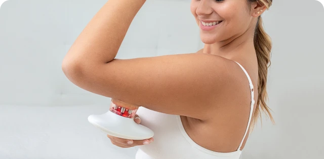 Massaging the legs with the Redu Sculpt device to support body contouring during an at-home routine.